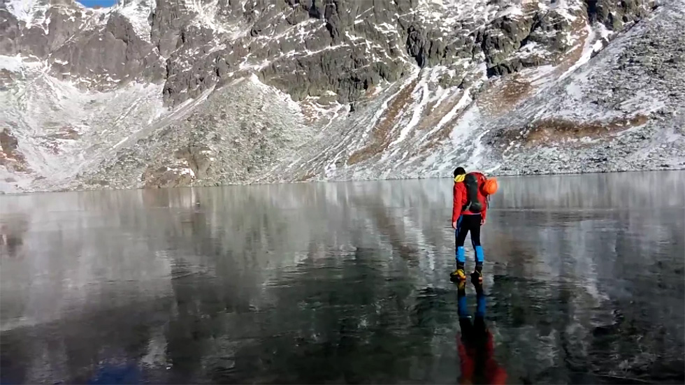 斯洛伐克徒步者行走高山湖冰面 晶莹剔透如履空气