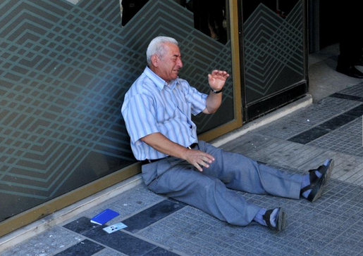 希腊77岁老翁跑四家银行提款未果 坐地痛哭