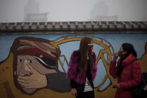 <p> In this Jan. 12, 2013 photo, a woman adjusts her mask while walking with her friend outside an amusement park on a polluted day in Beijing, China. Facing public outrage over smog-choked cities and filthy rivers, China&apos;s leaders are promising to clean up its neglected environment, a pledge that sets up a clash with political pressures to keep economic growth strong. (AP Photo/Alexander F. Yuan)