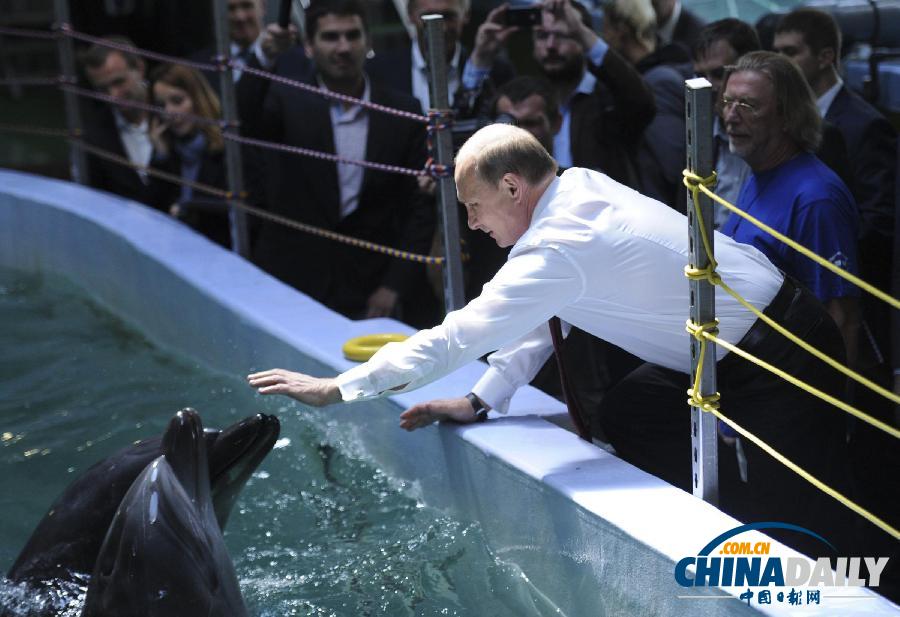 俄总统普京访问海洋馆 与小动物“亲密接触”