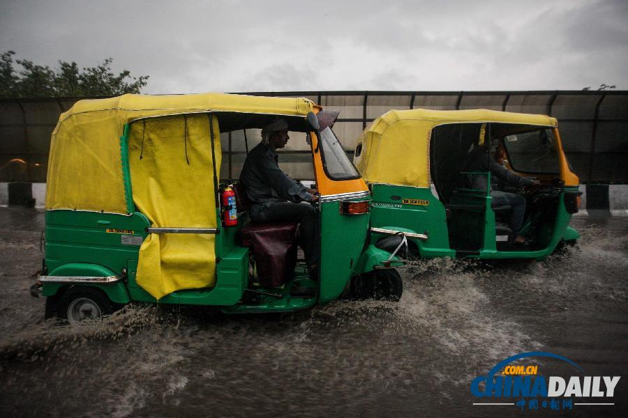 印度新德里遭遇强降雨 三轮出租车涉水载客（组图）