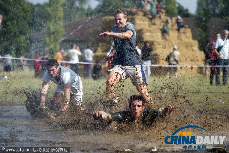 法国“泥浆节”首日比赛举行 在泥浆中行进13公里