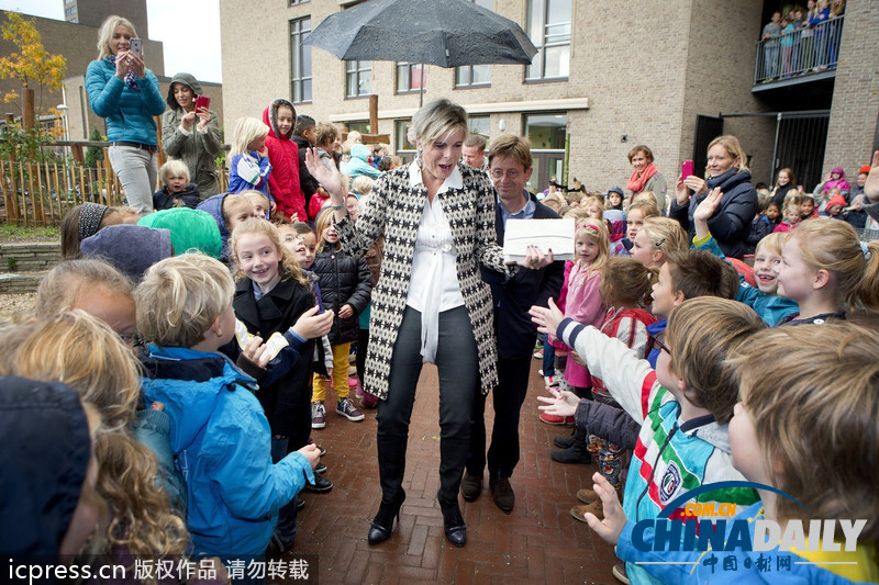 荷兰王妃探访学校专人撑伞 孩子们站立雨中迎接（组图）