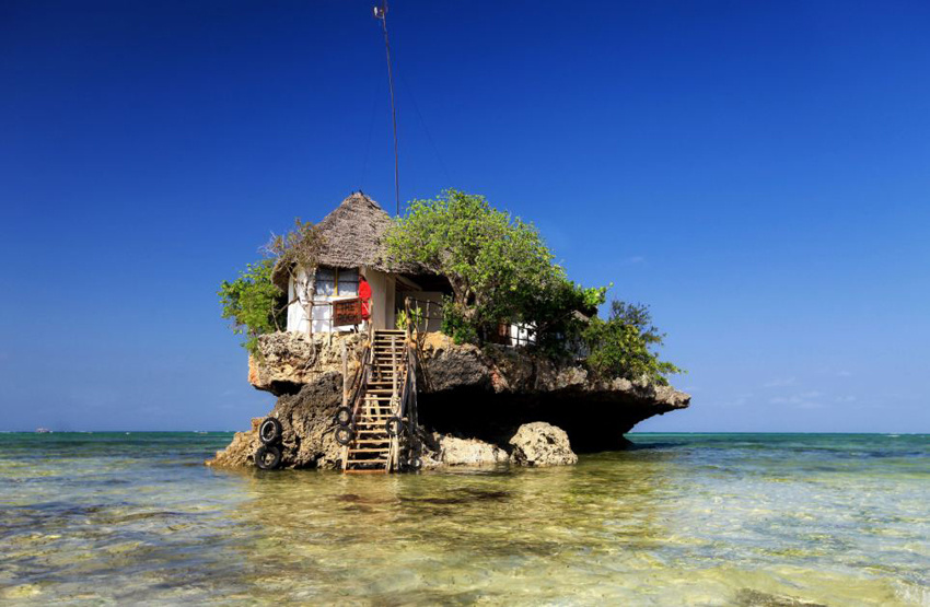 东非男子海滩岩石上建餐厅 四面环海享美味