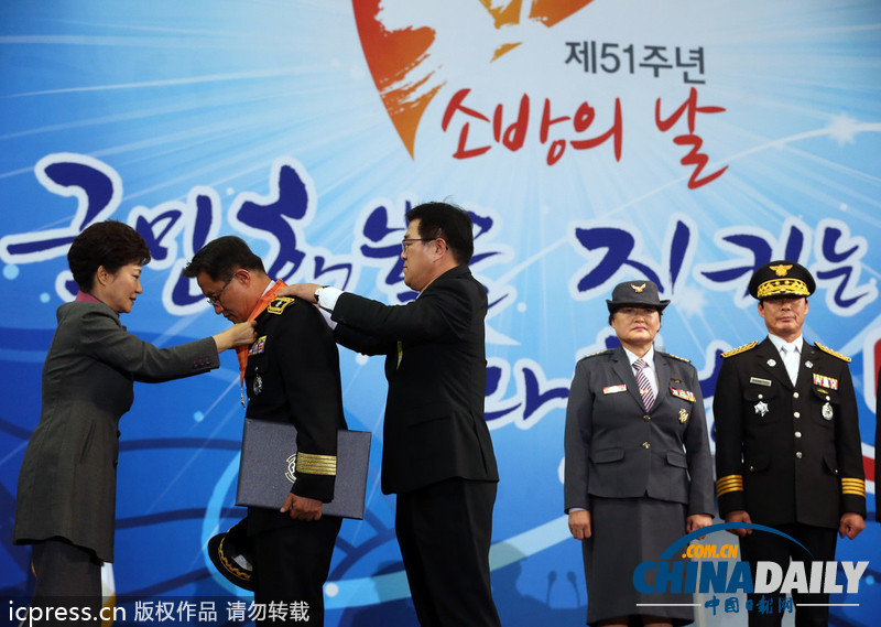 韩国庆祝消防日 总统朴槿惠亲自为消防员“穿衣”