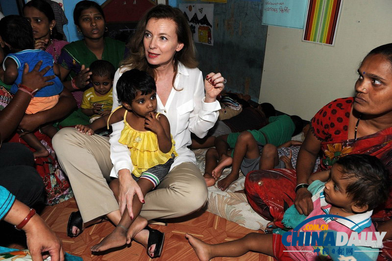 法前第一女友造访印度贫民窟 盘腿而坐抱孩子秀亲民
