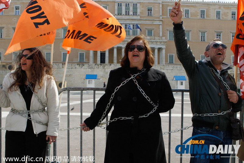 希腊教师高举拖把扫帚 用铁链锁身体抗议裁员