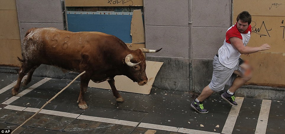 直击西班牙奔牛节活动：牛角刺穿参与者大腿