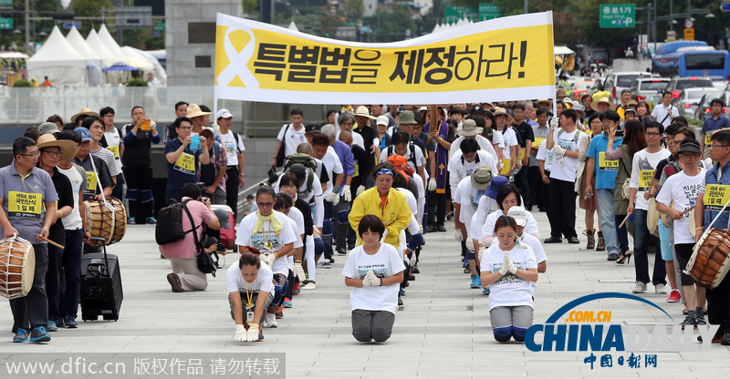 韩国沉船事故遇难者家属集体跪地叩拜 敦促制定特别法