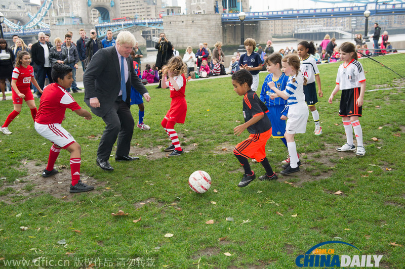 伦敦市长与小学生踢足球 伸腿绊倒小足球队员
