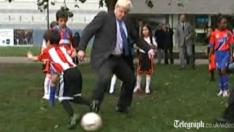 伦敦市长与小学生踢足球 伸腿绊倒小足球队员