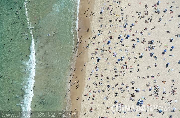 澳海滩数千人日光浴游泳 摄影师俯拍海岸线别样美景