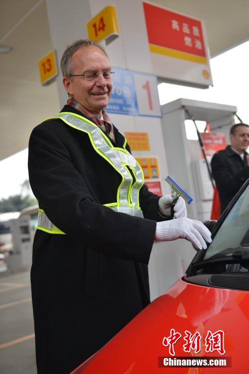 荷兰经济大臣加油站为成都市民擦车加油