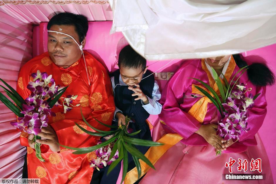 泰国新婚夫妇情人节办婚礼 躺粉色棺材求好运