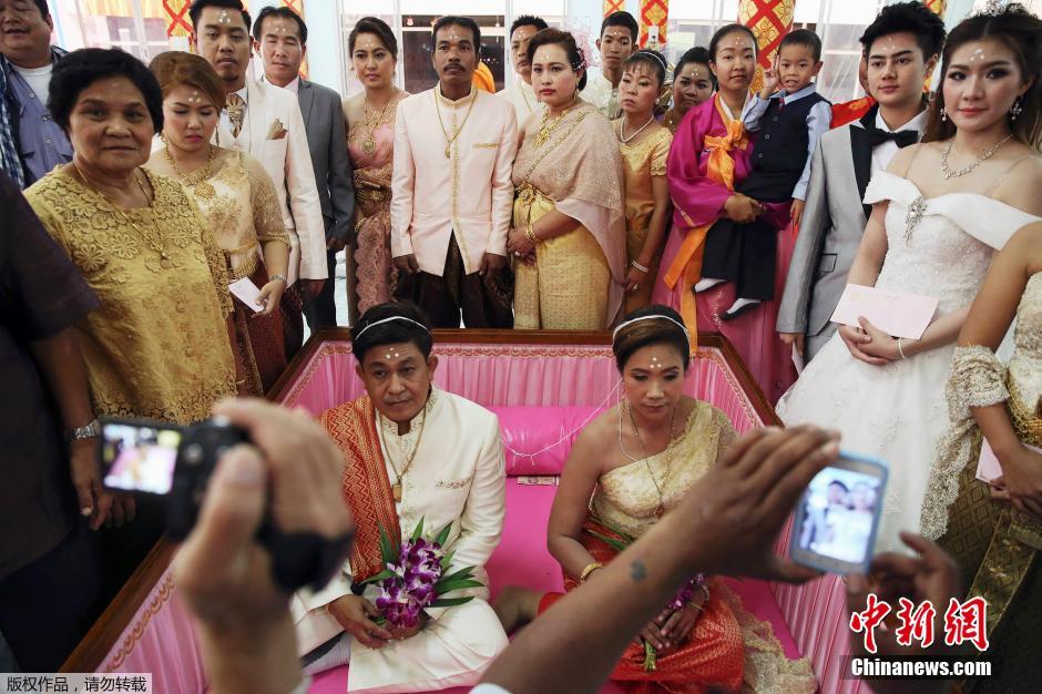 泰国新婚夫妇情人节办婚礼 躺粉色棺材求好运