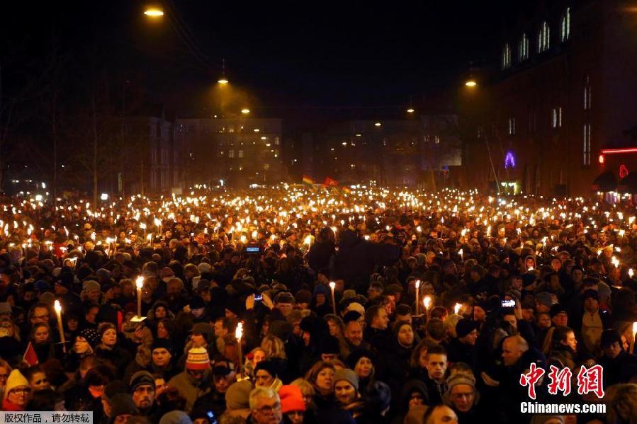 丹麦民众手持火把集会悼念枪击案遇难者