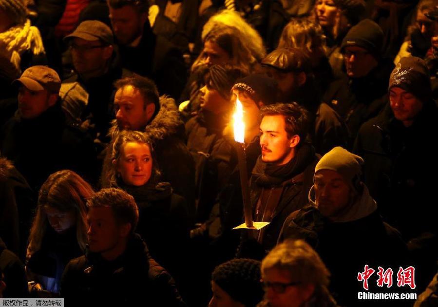 丹麦民众手持火把集会悼念枪击案遇难者