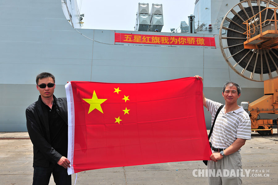 两名中国同胞在撤离现场举起了五星红旗.(熊利兵摄)