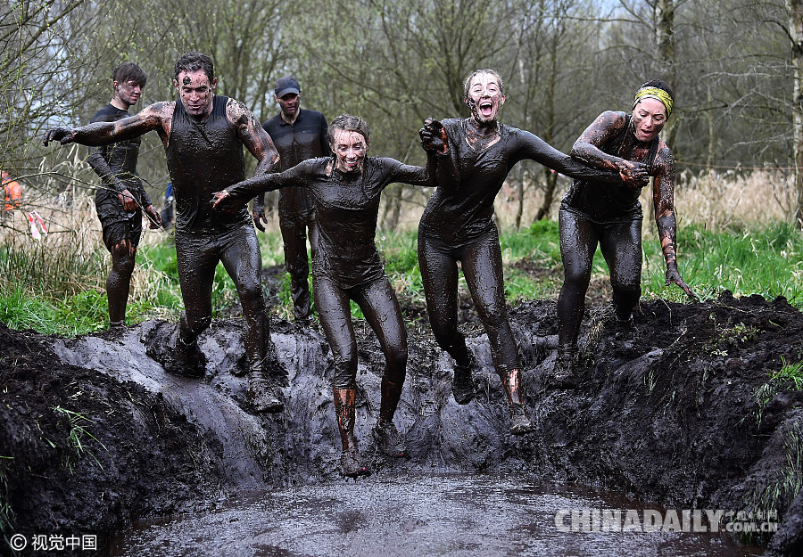 英国举行泥地穿越赛 参赛者飞身入泥浆