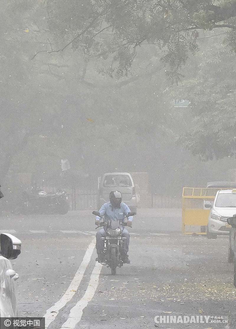 印度出现沙尘暴伴随小雨天气 民众冒风沙淋雨消暑
