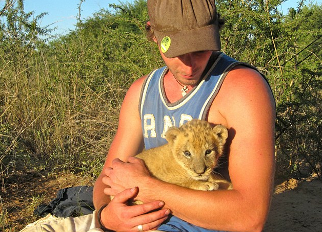 非洲南部草原罕见场景：雌狮与人类伙伴亲密拥抱