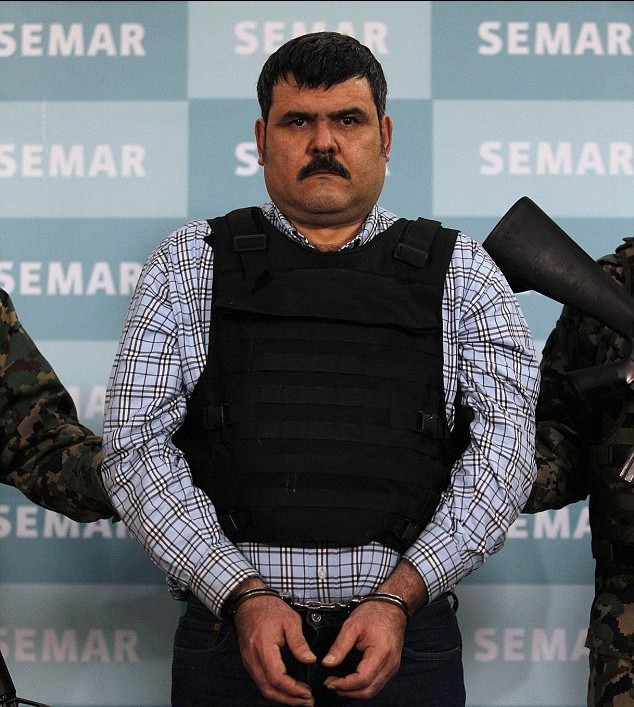 墨西哥毒枭落网竖起拇指供记者拍照 警方展示其镶金AK47