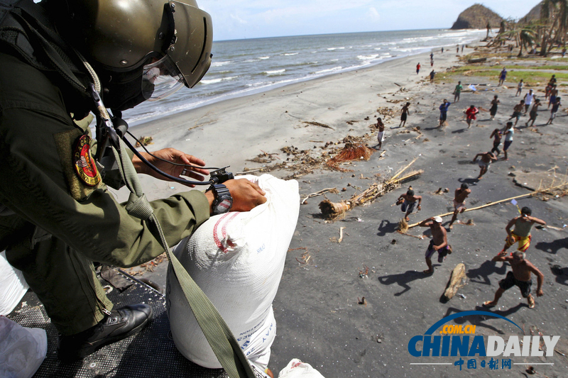 菲律宾空军向台风灾区投掷粮食 灾民奔跑抢夺