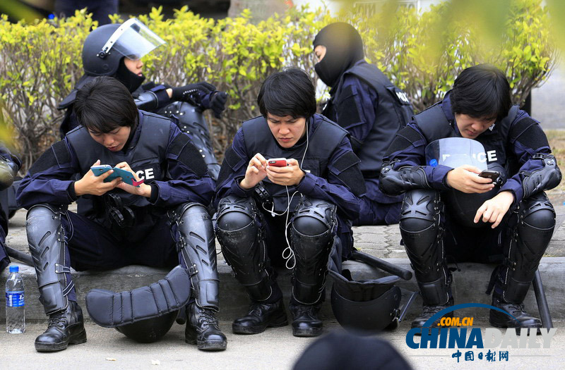 泰国稻农取消机场示威 防暴警察得闲玩手机