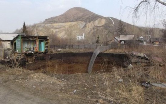 哈萨克斯坦突现30米深巨坑 一对母子险随房屋被吞
